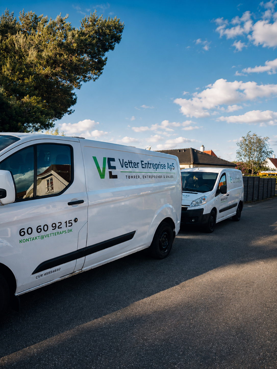 To hvide varevogne med Vetter Entreprises logo og telefonnummer